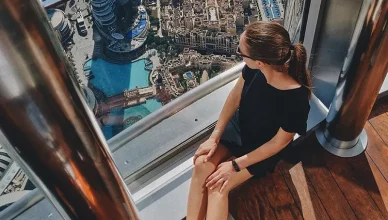 Woman enjoying panoramic city view from Burj Khalifa Sky Lounge