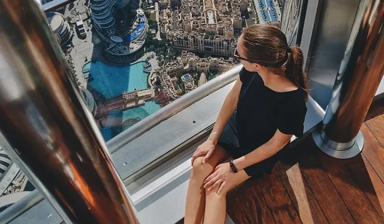 Woman enjoying panoramic city view from Burj Khalifa Sky Lounge