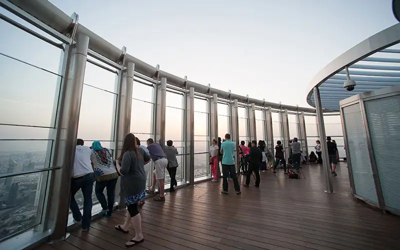 People enjoying Dubai view at sunset from Burj Khalifa