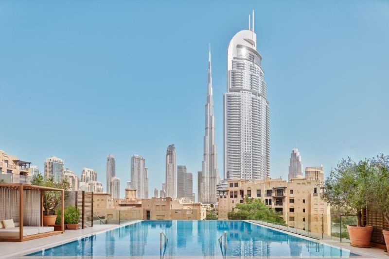 Serene poolside at The Dubai Edition, framed by lush greenery and iconic Downtown skyline.