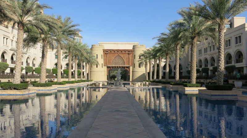 Enjoy the beautiful view of palm trees by the serene pool at Palace Downtown, Dubai.